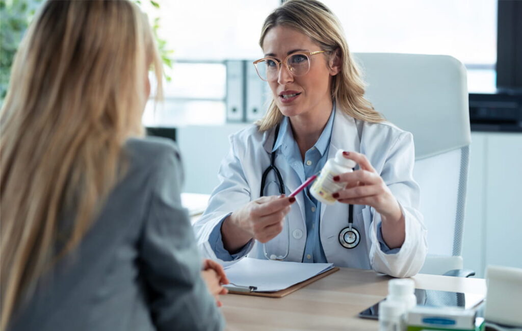 Doctor explaining medication to female patient.